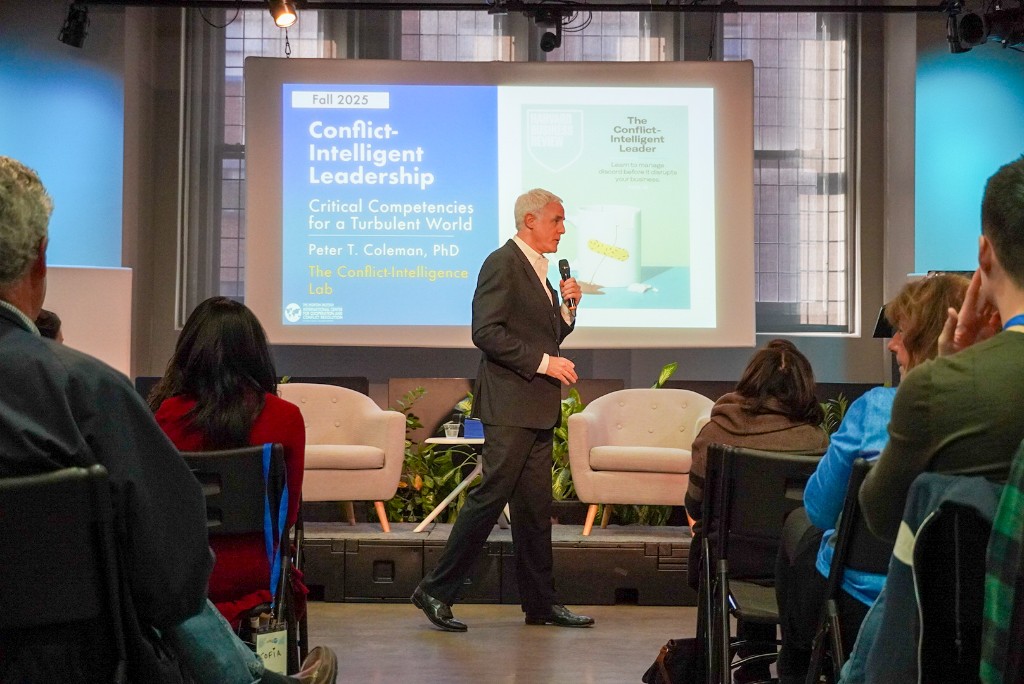 Peter Coleman delivering a Conflict-Intelligent Leadership keynote with The Conflict-Intelligent Leader on screen